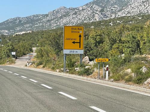 a yellow street sign on the side of a road at Kuća za odmor “Dida” in Stinica
