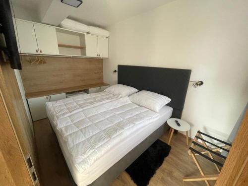 a bedroom with a bed with a white comforter at Apartman 511 in Lipno nad Vltavou