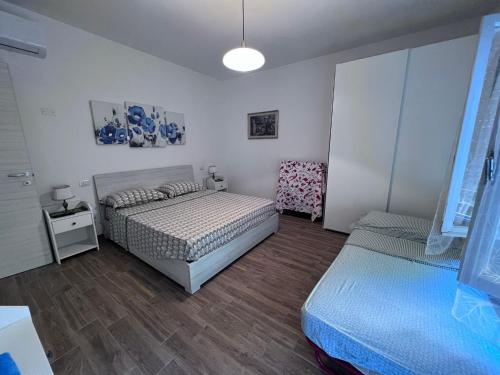 サン・ベネデット・デル・トロントにあるCasa Ririのベッドルーム1室(ベッド2台、テーブル、ランプ付)