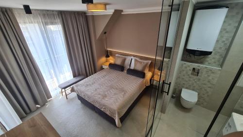 a small bedroom with a bed and a shower at NEA Apartments in Ahtopol