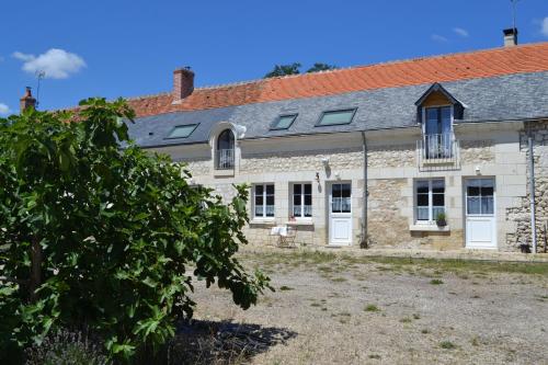 une ancienne maison en pierre avec un toit rouge dans l'établissement Escale à Villeperdue chambre SAAREMAA, à La Barillonnerie