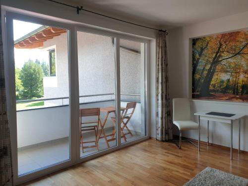 a sliding glass door leading to a balcony with a table and chairs at Ferienwohnung Jäger in Strassen