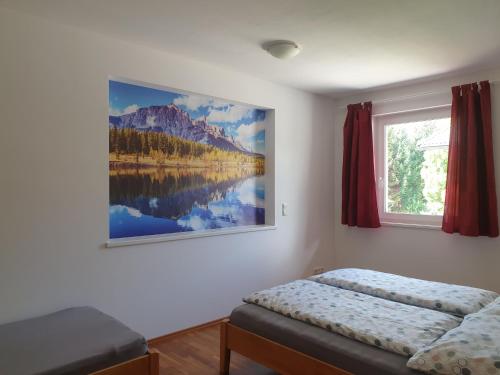 施特拉森的住宿－Ferienwohnung Jäger，卧室配有一张床,墙上挂有绘画作品