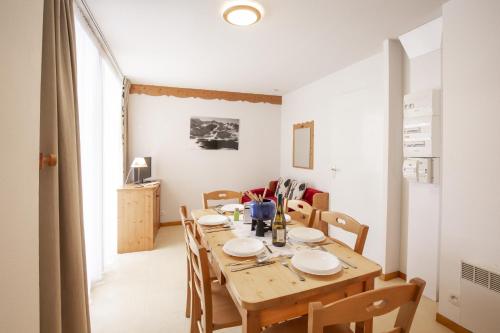 a dining room with a wooden table and chairs at Les Balcons PROCHE PARC NATIONAL VANOISE appartements 2 pieces 5 pers in Termignon