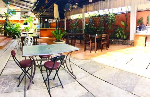 uma mesa e cadeiras num restaurante com plantas em B&J Guesthouse and Tours em Tagbilaran City