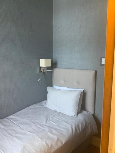 a bed with white sheets and pillows in a room at The Rockley Hotel in Blackpool