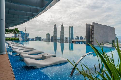 einen Pool mit einer Skyline der Stadt im Hintergrund in der Unterkunft Eaton Residence KLCC in Kuala Lumpur