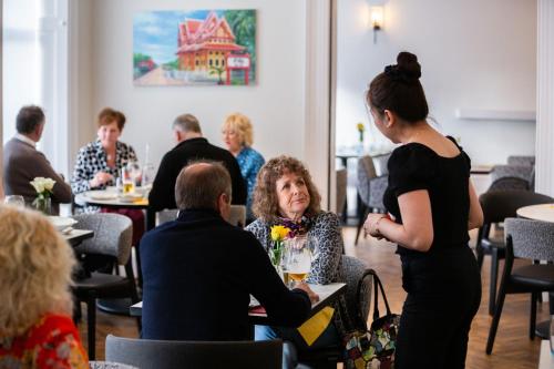 a woman standing in a restaurant talking to a woman at The Juniper Rooms in Montrose