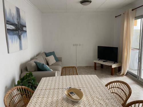 sala de estar con mesa y sofá en Cozy Apartment in Centre of Alicante near Plaza de Toros en Alicante