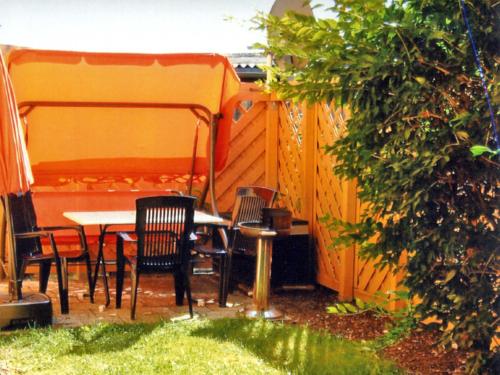 einen Tisch und Stühle in einem Hinterhof mit einem Zaun in der Unterkunft Ferienhaus Mirada in Blankenhagen