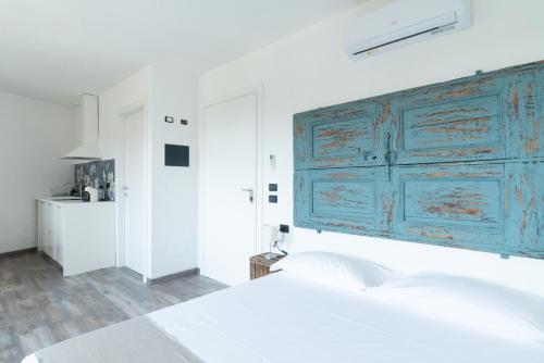 um quarto branco com um armário azul por cima de uma cama em LA CORTE SUL LAGO em Merone