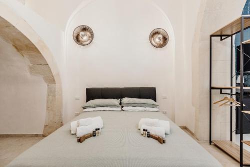 I Dammusi di Via Vittorio Veneto في سيراكوزا: غرفة نوم عليها سرير ووسادتين