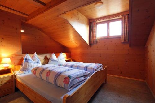 a bedroom with a bed in a log cabin at Appartement Wurzrainer in Westendorf