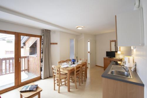 a kitchen and dining room with a table and chairs at Les Balcons PROCHE PARC NATIONAL VANOISE appartements 2 pieces 6 pers CABINE in Termignon