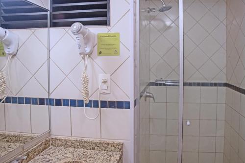y baño con ducha y secador de pelo. en Atobá Praia Hotel, en Balneário Camboriú