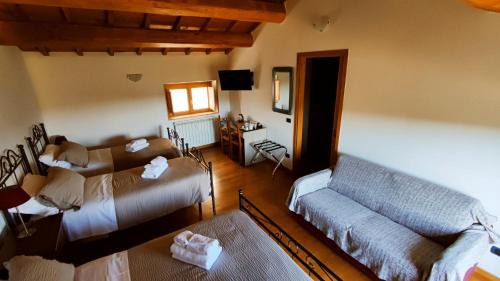 sala de estar con 2 camas y sofá en A 2 Passi dal Lago en Grotte di Castro