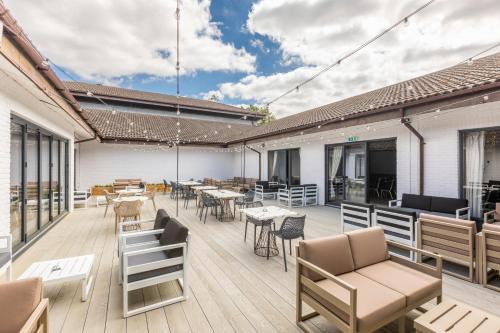 an outdoor patio with tables and chairs and tablesktop at Holiday Inn Guildford by IHG in Guildford