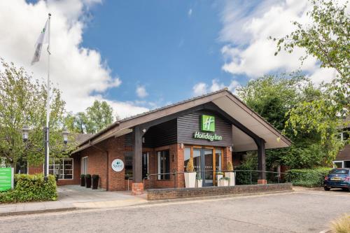 a building with a sign on the front of it at Holiday Inn Guildford by IHG in Guildford