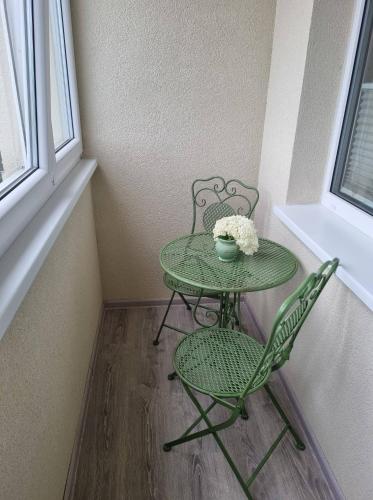 a table with two chairs and a table with a bowl of flowers at Pas Romaną in Zarasai