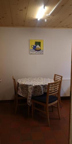 a table with four chairs and a painting on a wall at Apartment in Selatrað - Free parking in Selatrað