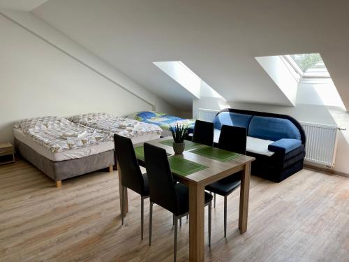 1 dormitorio con 1 cama, mesa y sillas en Guesthouse Piller, en Chvalín