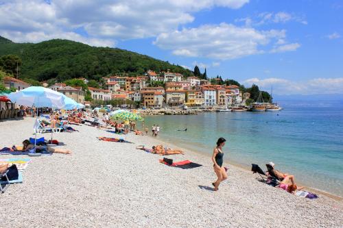 a group of people on a beach in the water at Apartments by the sea Moscenicka Draga, Opatija - 17381 in Mošćenička Draga