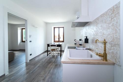 uma casa de banho branca com um lavatório e uma mesa em LA CORTE SUL LAGO em Merone