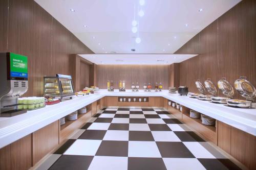 a restaurant with a checkered floor in a store at Holiday Inn Express Jakarta International Expo by IHG in Jakarta