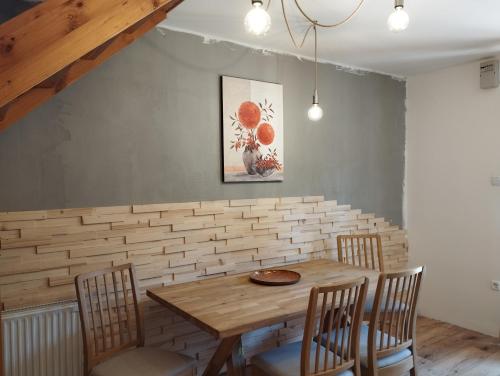 uma sala de jantar com uma mesa de madeira e cadeiras em Liliomfa apartman em Szigliget