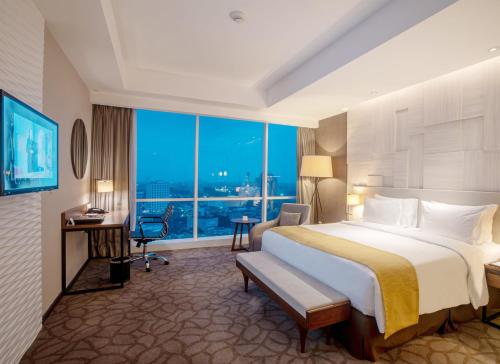 a hotel room with a large bed and a large window at Crowne Plaza Bandung by IHG in Bandung