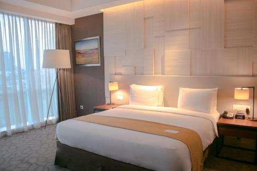a bedroom with a large bed in a hotel room at Crowne Plaza Bandung by IHG in Bandung