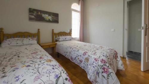 a bedroom with two beds and a window at La casa de la tinaja piscina y chimenea by Toledo AP in Villamiel de Toledo
