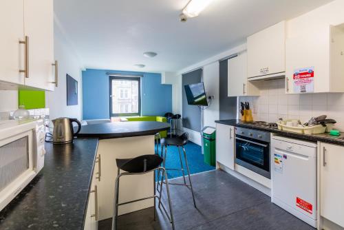 a kitchen with a stove top oven and a microwave at Destiny Student – Shrubhill (Campus Accommodation) in Edinburgh