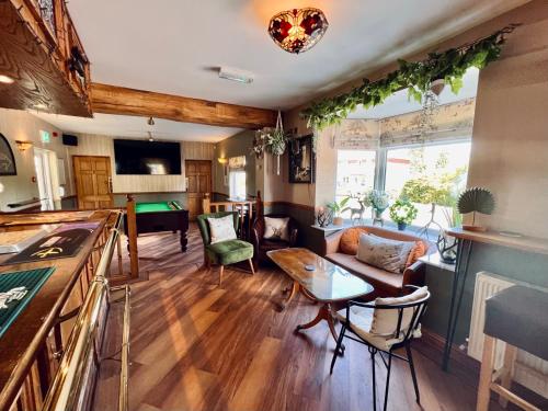 uma sala de estar com um sofá e uma mesa de bilhar em The Reindeer Inn em Sandtoft