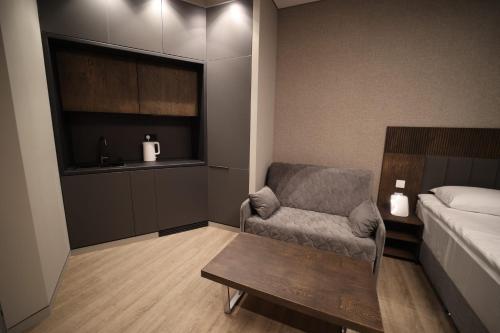a bedroom with a bed and a chair and a table at AVENUE RESIDENCE by AY North Avenue in Yerevan