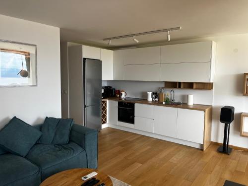a living room with a couch and a kitchen at Merlo APP in Labin