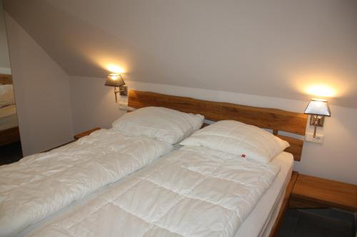 1 cama con 2 almohadas en una habitación en Seeblick 8 - Luxus direkt am Hafen von Norddeich en Norddeich