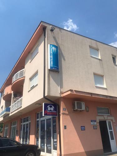 a building with a car parked in front of it at Apartman Petar Pan in Grude