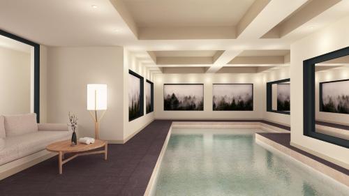 a living room with a pool with a couch and paintings at Les Suites de la Potinière in Courchevel