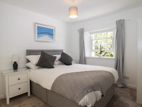 a bedroom with a large bed and a window at Apartment at Morningside Hotel in Torquay
