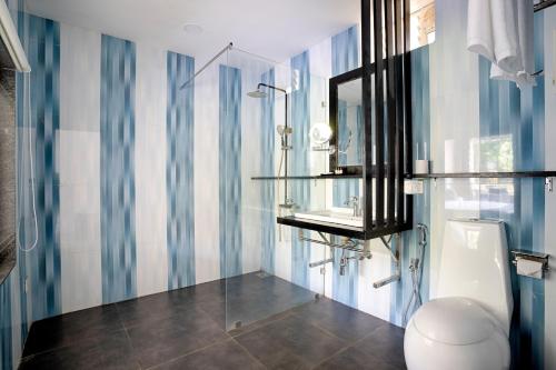 a bathroom with a toilet and a sink and a mirror at Koko Maya By Stone Wood, Morjim in Morjim