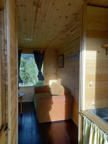 Habitación con sofá en el interior de una cabaña en casita en la montaña, cabañas paraíso, en Sesquilé