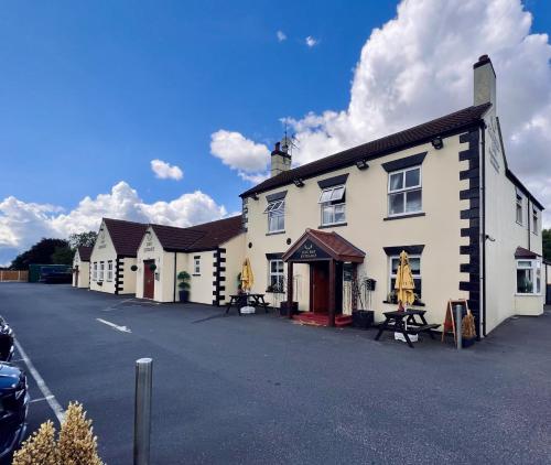 a row of white buildings in a parking lot at The Reindeer Inn in Sandtoft