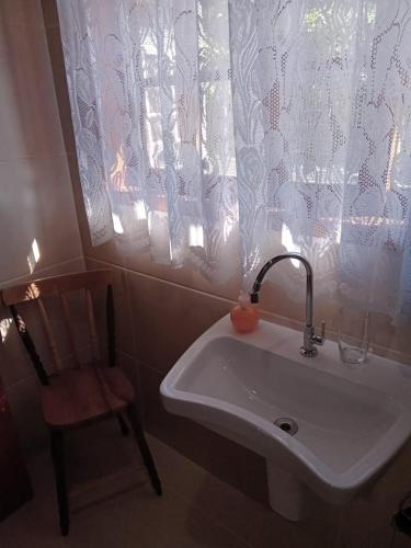 a bathroom with a sink and a chair and a window at Vivenda Fagundes in Florianópolis