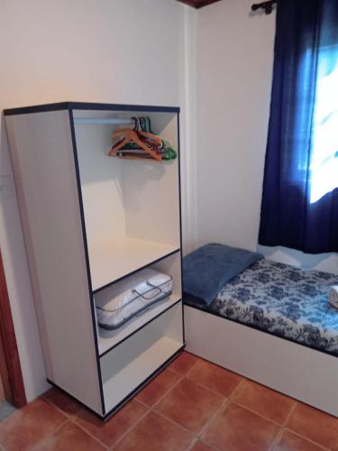 a small bedroom with a bed and a cupboard at Vivenda Fagundes in Florianópolis