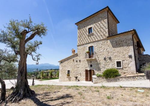 an old stone building with a tree in front of it at Agriturismo Torre Gialluise in Gesualdo