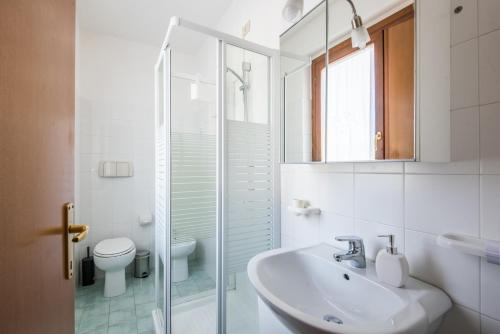 La salle de bains blanche est pourvue d'un lavabo et de toilettes. dans l'établissement Casa Vacanze Chianti Summer, à Gaiole in Chianti