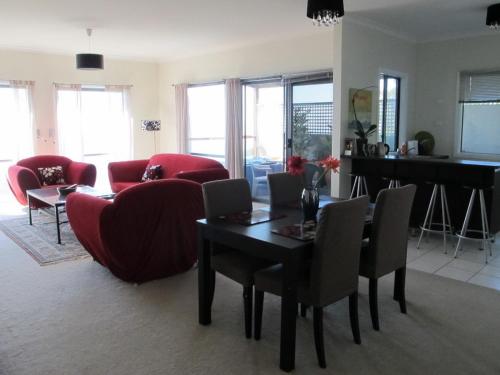 a living room with a red couch and a table at Bonza View in Kalorama