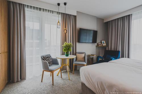 a hotel room with a bed and a table and chairs at Royal Tulip Warsaw Centre in Warsaw