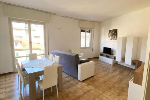 sala de estar con mesa y sofá azul en La casa di Andrea Grande Appartamento a due passi dalle spiagge, en Rapallo
